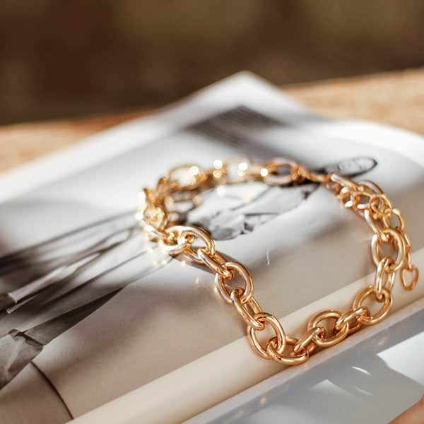 permanent jewelry bracelet laying on a magazine