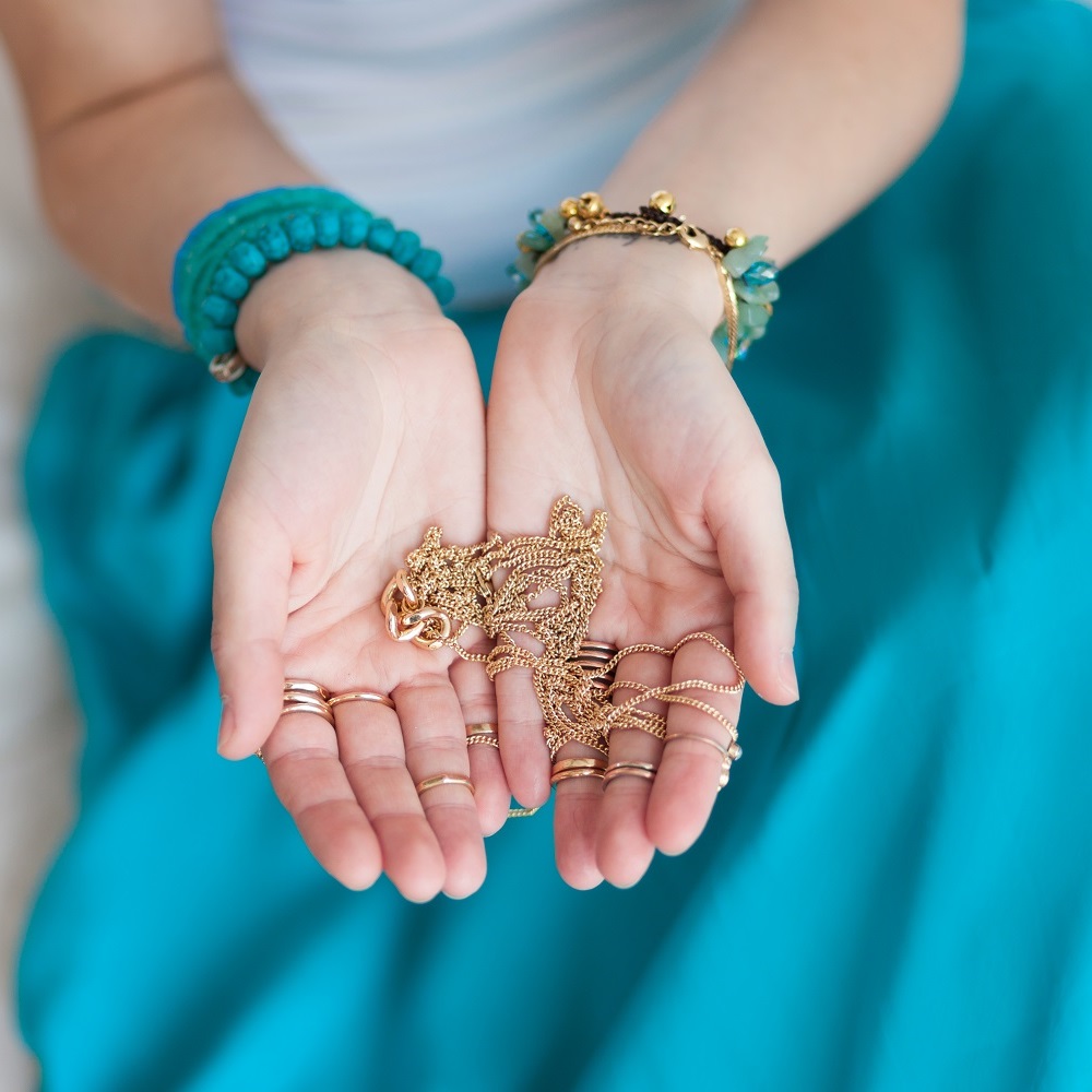 woman holding gold jewelry chains