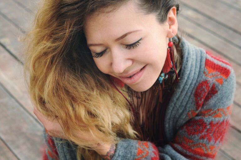 woman smiling wearing fall earrings and sweater