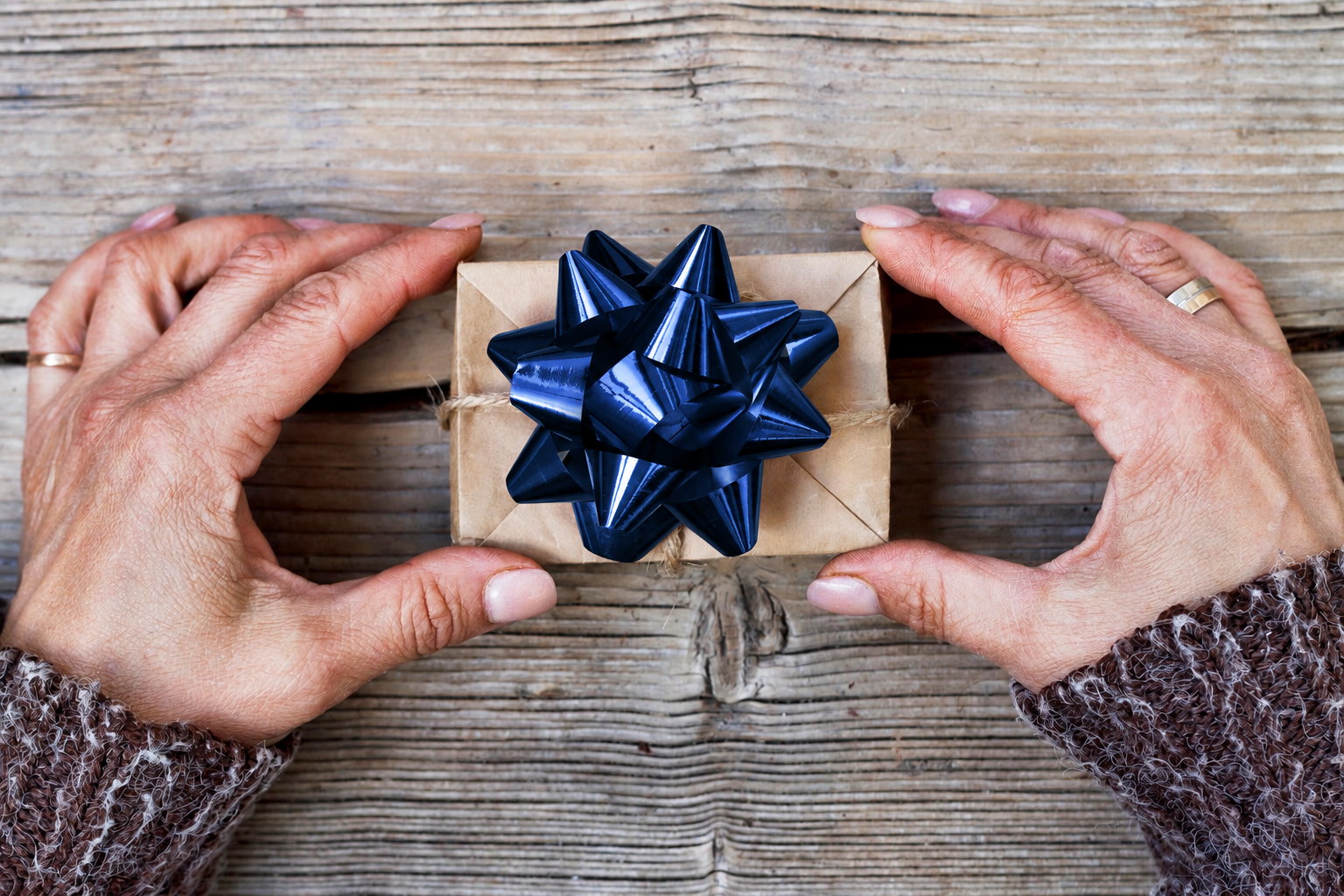 hands holding a permanent jewelry experience gift