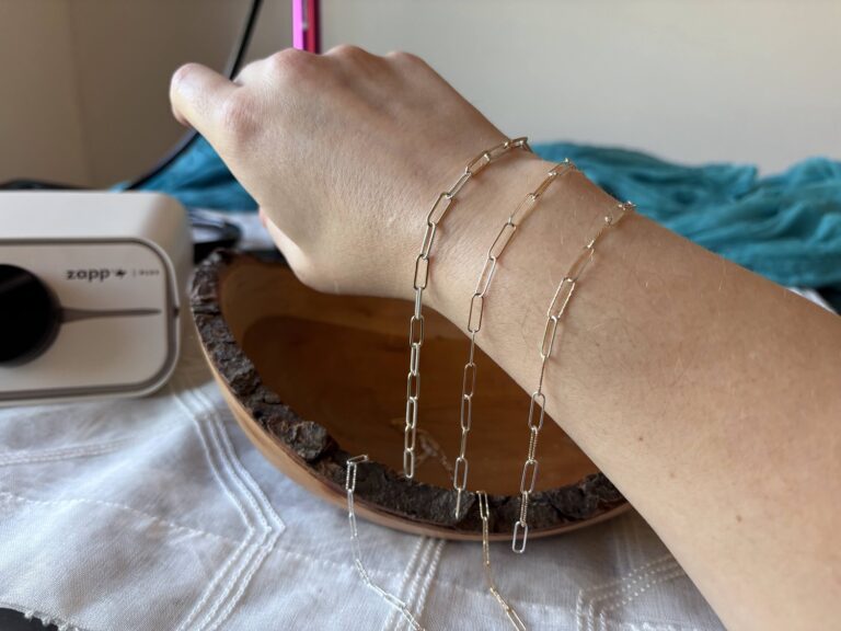 mixed metal permanent jewelry chain draped on a woman's wrist